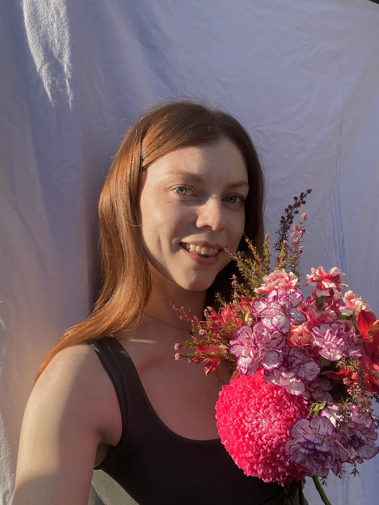 Woman holding a bouquet of flowers against a white backdrop
